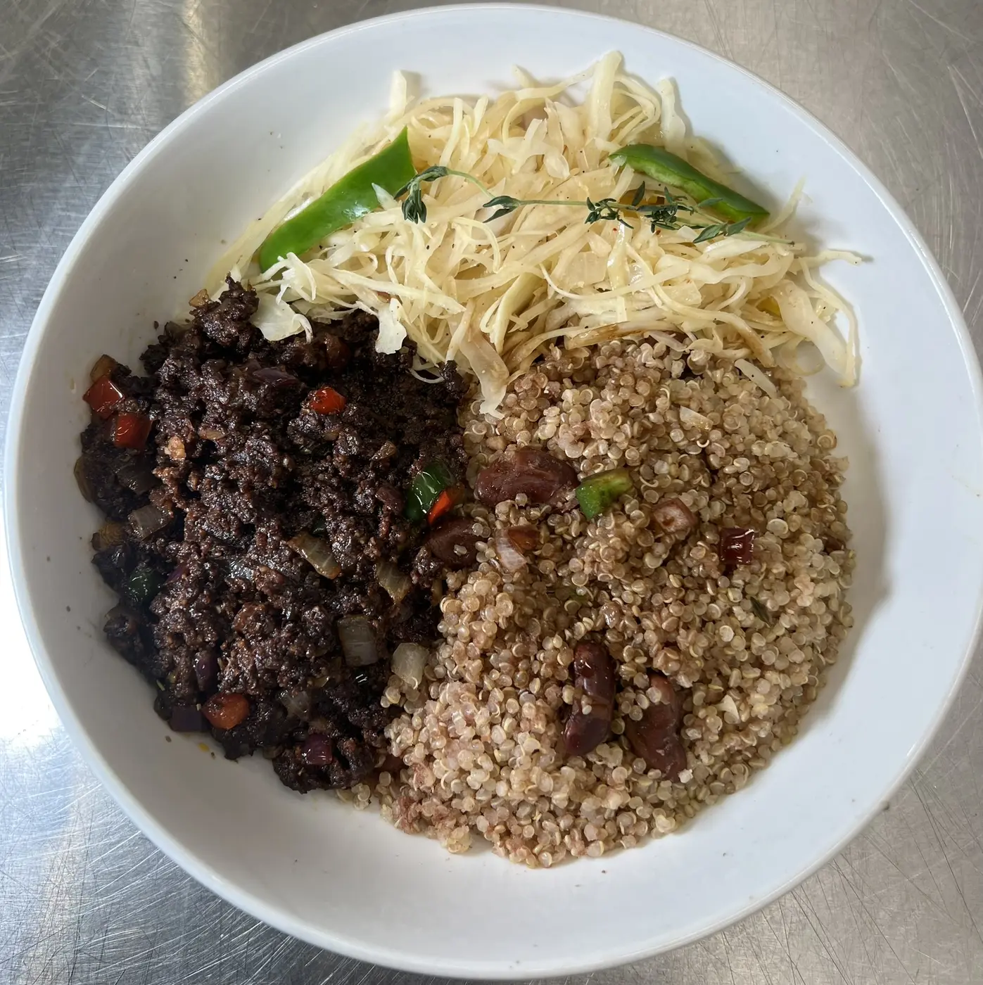 Whole-food oxtail-style vegan meat with quinoa and peas and cabbage